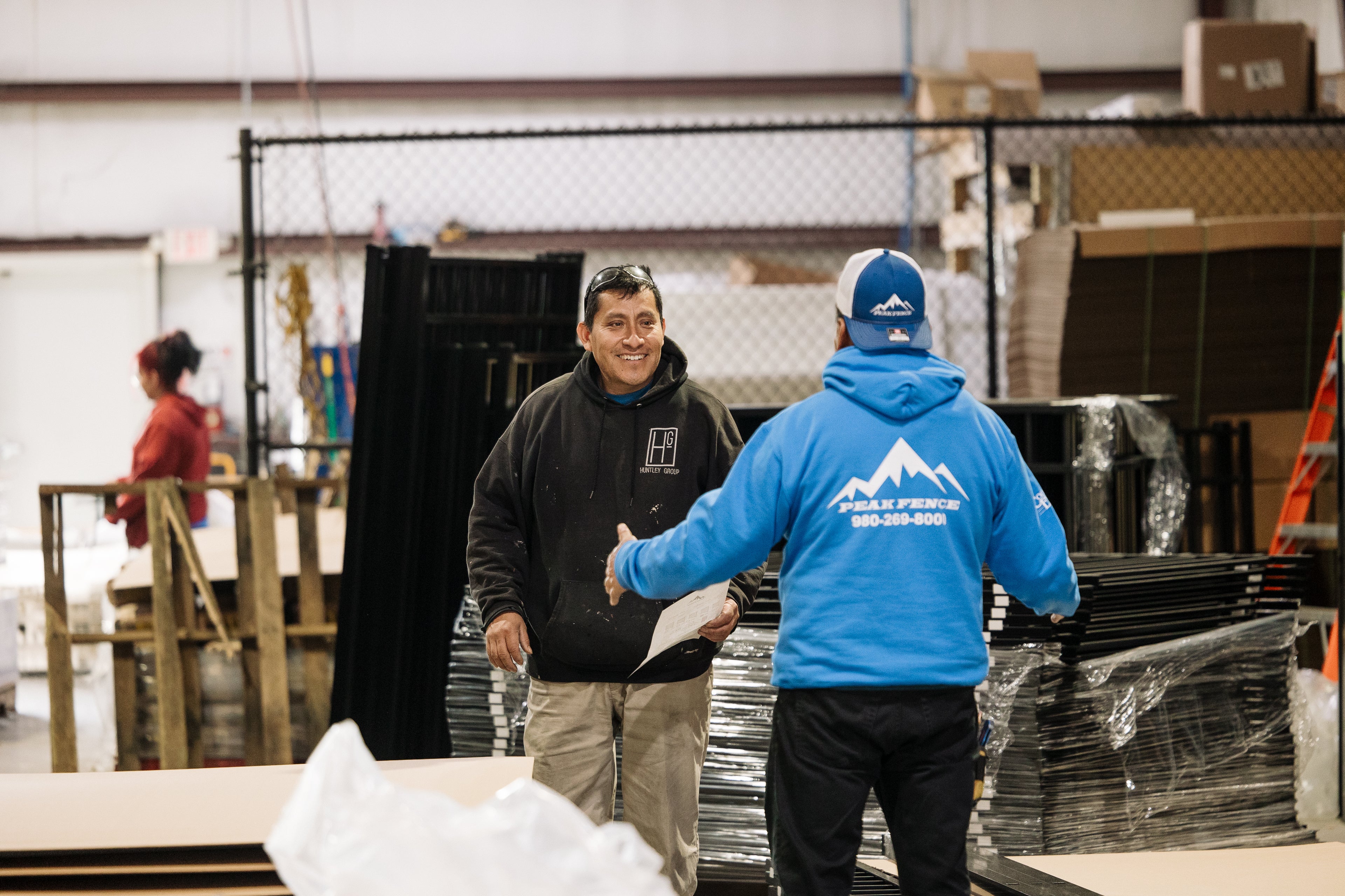 two peak fence employees talking to each other